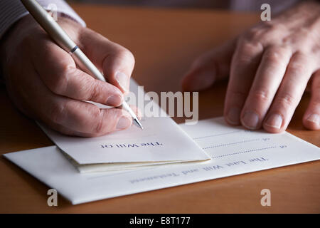 Close Up Of Man Completing Last Will And Testament Stock Photo