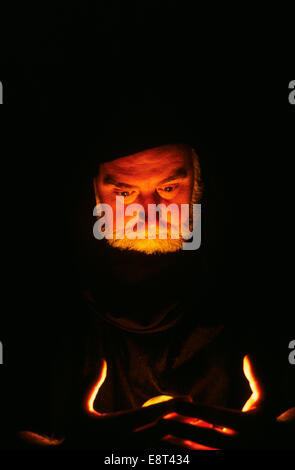 CHARACTER MAN WIZARD OR FORTUNE TELLER LOOKING DOWN INTO EERIE LIGHT Stock Photo