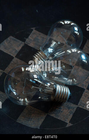 three light bulbs turned off on a checkered surface Stock Photo