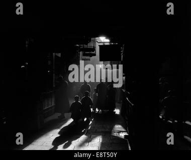 1920s 1930s SILHOUETTED PEOPLE MYSTERIOUS ORIENT DRAMATIC MOODY BACKLIT STREET SCENE IN OLD CHINESE CITY SHANGHAI CHINA Stock Photo