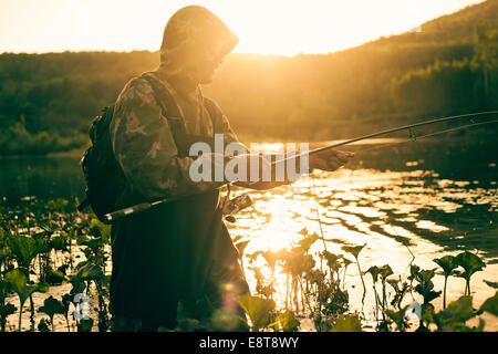 Mari man fishing in lake Stock Photo
