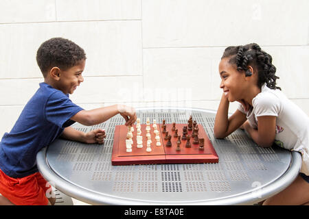 African American brother and sister playing chess Stock Photo