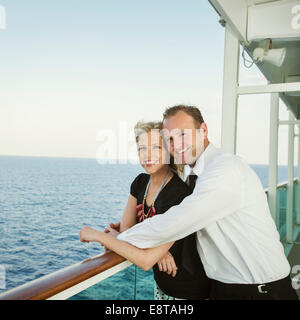 Caucasian couple hugging on boat deck Stock Photo