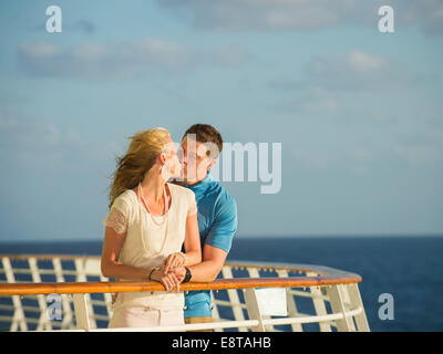 Caucasian couple kissing on boat deck Stock Photo