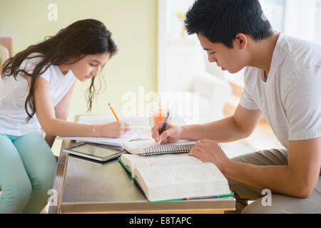 Hispanic brother and sister doing homework Stock Photo