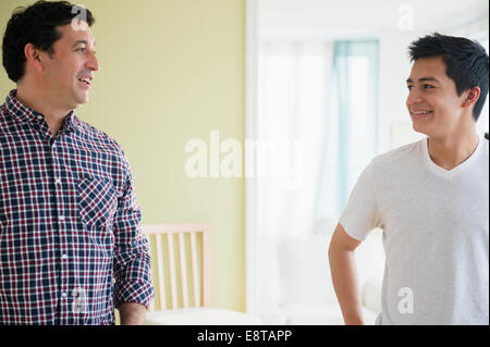 Hispanic father and son talking Stock Photo