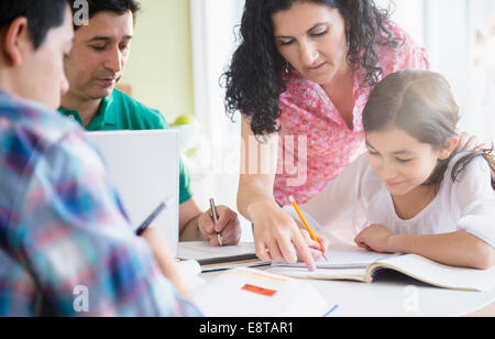 Hispanic family doing homework together at table Stock Photo