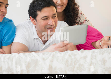 Hispanic family using digital tablet together