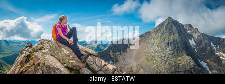 Caucasian girl sitting on rocky mountain Stock Photo