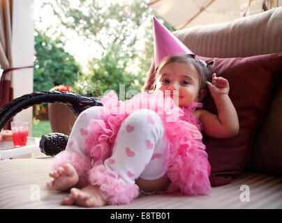 Smiling mixed girl wearing party hat Stock Photo