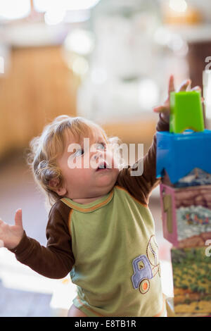 Caucasian baby boy reaching for blocks Stock Photo
