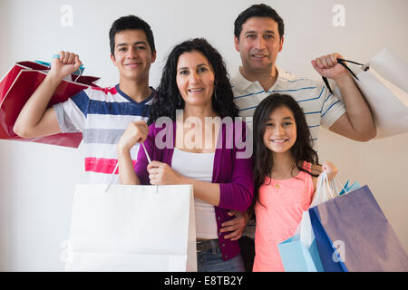 Hispanic family holding shopping bags together Stock Photo