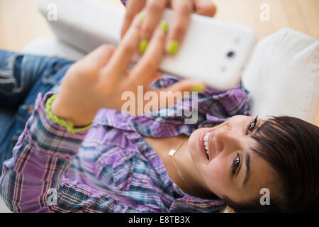 Mixed race woman taking selfie with cell phone Stock Photo