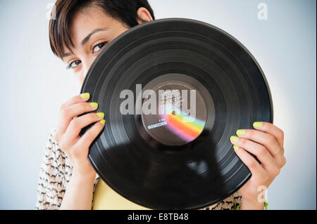 Mixed race woman holding vinyl record Stock Photo