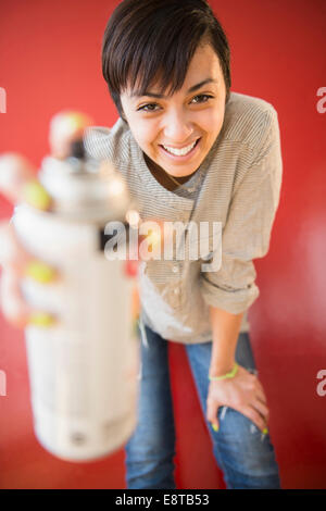 Smiling mixed race woman holding canister of spray paint Stock Photo