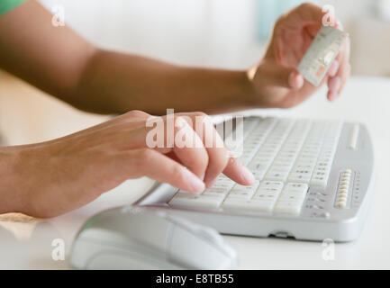 Mixed race man shopping online with credit card Stock Photo