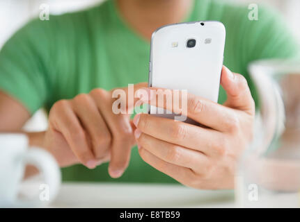 Close up of mixed race man using cell phone Stock Photo