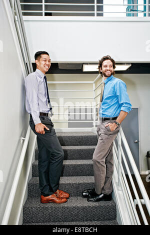 Businessmen standing on staircase Stock Photo