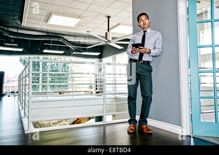 Chinese businessman using digital tablet outside office Stock Photo