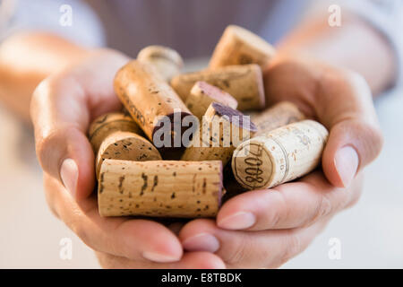 Close up of mixed race man holding wine corks Stock Photo