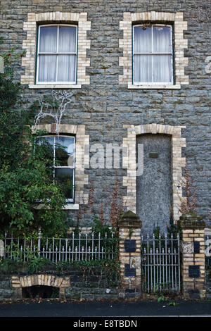 Knighton, Powys, Wales, UK. A sinister grey stone Victorian house with the front door walled up or bricked up Stock Photo