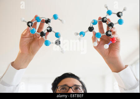 Close up of mixed race scientist holding molecular models Stock Photo