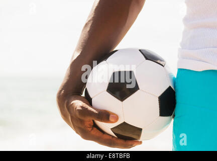 Mixed race man holding soccer ball Stock Photo