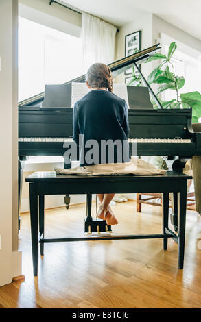 Mixed race girl playing piano Stock Photo