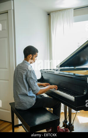 Mixed race boy playing piano Stock Photo