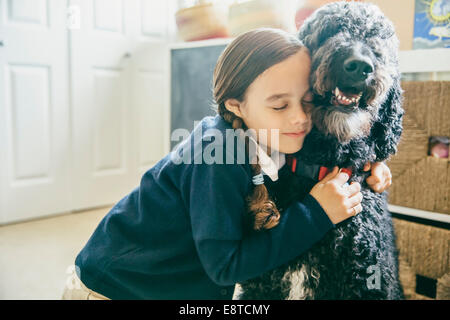 Mixed race girl hugging dog Stock Photo