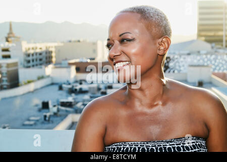 Black woman smiling on urban rooftop Stock Photo