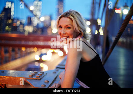 Caucasian woman leaning on railing on Brooklyn Bridge, New York City, New York, United States Stock Photo