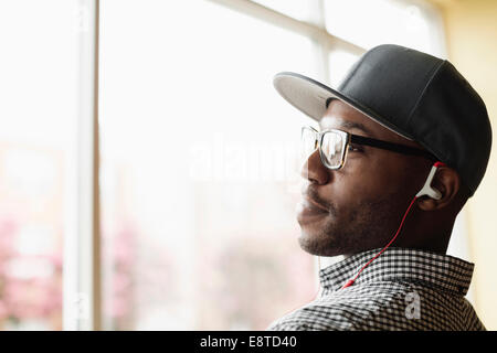 Black man listening to headphones indoors Stock Photo