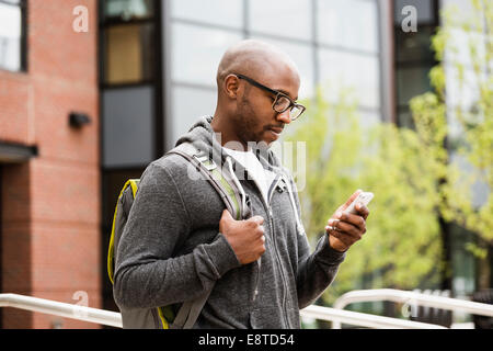 Black man using cell phone on city street Stock Photo