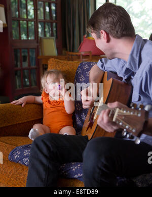 Caucasian father playing guitar for daughter Stock Photo