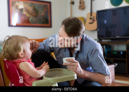 Caucasian father feeding toddler daughter Stock Photo