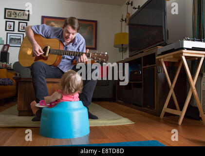 Caucasian father playing guitar for daughter Stock Photo