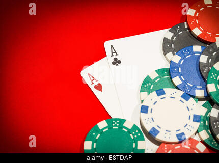 Pair of aces and chips on a red table Stock Photo
