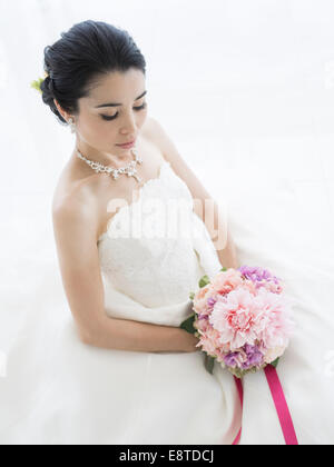 Mixed race, Asian / American bride in white wedding dress Stock Photo