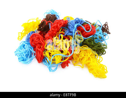 Multi-coloured embroidery threads in a tangled heap, isolated on a white background Stock Photo