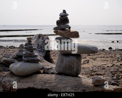 Stacks of pebbles on a log, Monmouth Beach, Lyme Regis, Dorset, UK Stock Photo