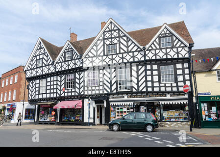 A row of shops in old black and white timber-framed buildings on the corner of Market Place in the historic town of Warwick Stock Photo