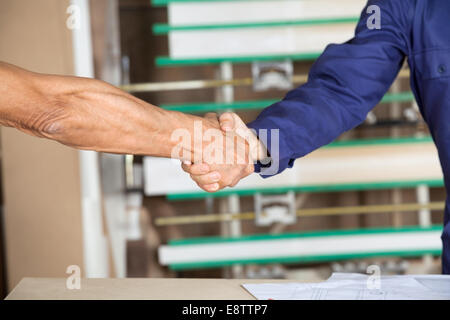Cropped Image Of Carpenters Shaking Hands Stock Photo