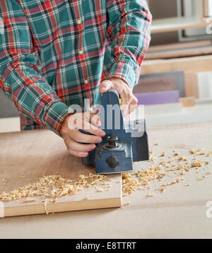 Midsection Of Carpenter Working With Electric Planer Stock Photo