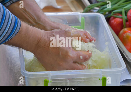man hands knead the chopped onion closeup Stock Photo