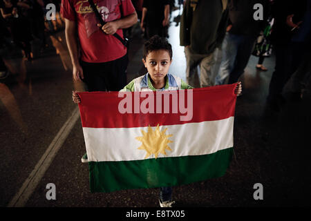 Thessaloniki, Greece. 14th October, 2014. A Kurdish child who lives in Greece holds a Kurdish flag during a pro-Kurd demonstration against attacks launched by Islamic State insurgents targeting the Syrian city of Kobane in Thessaloniki, Greece on Oct. 14, 2014. Credit:  Konstantinos Tsakalidis/Alamy Live News Stock Photo