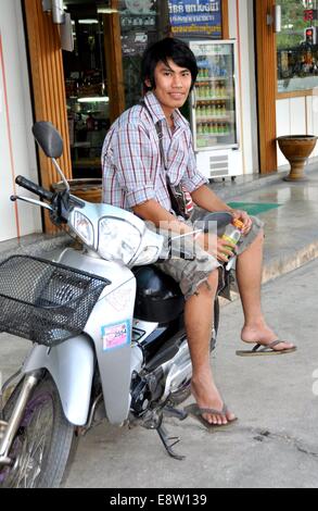 KANCHANABURI, THAILAND:  Young Thai man sitting on his motorcycle Stock Photo