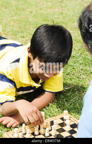 1 Indian Man Playing Chess with Kid Stock Photo