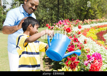 1 Indian Man Spraying Water with kid Stock Photo