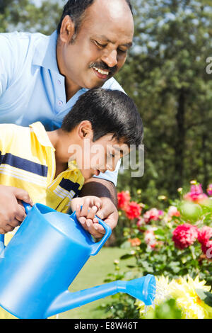 1 Indian Man Spraying Water with kid Stock Photo